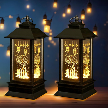 Two illuminated lanterns with decorative patterns on a blurred background of lights.