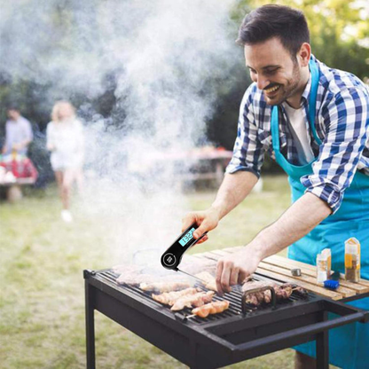 Man grilling outdoors using a digital thermometer, with family in the background