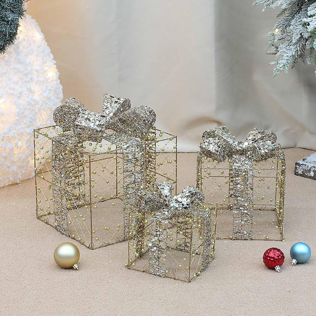 Decorative wire gift boxes with silver ribbons and Christmas ornaments on a neutral background