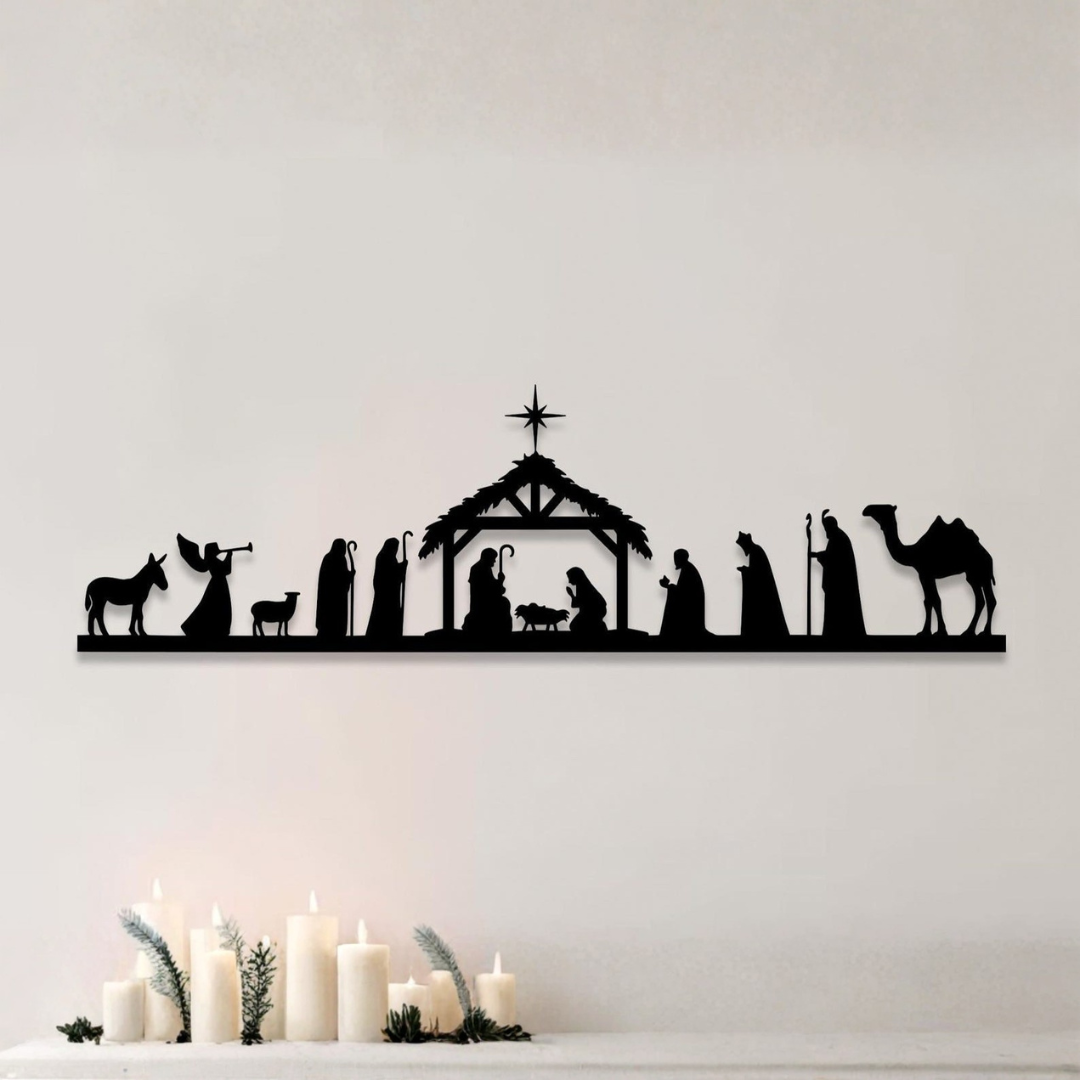 Silhouette of a nativity scene on a white wall with candles below.