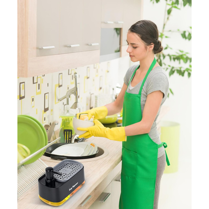 Woman in a kitchen wearing a green apron and yellow gloves, using a portable dishwashing machine.